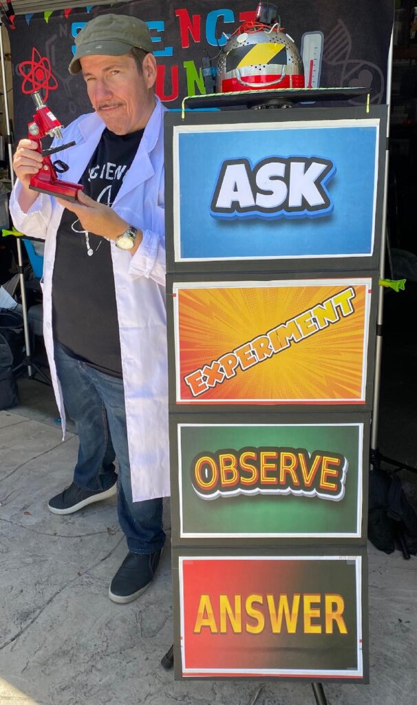 Robert Baxt Scientist Standing with Signs